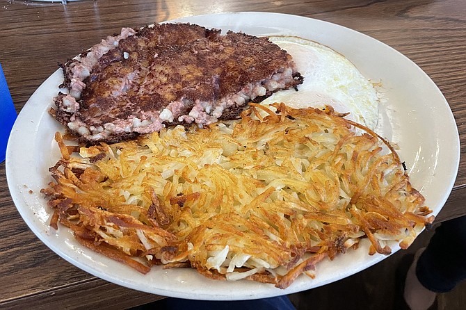 A classic breakfast diner order: corned beef hash with hash browns and eggs over easy