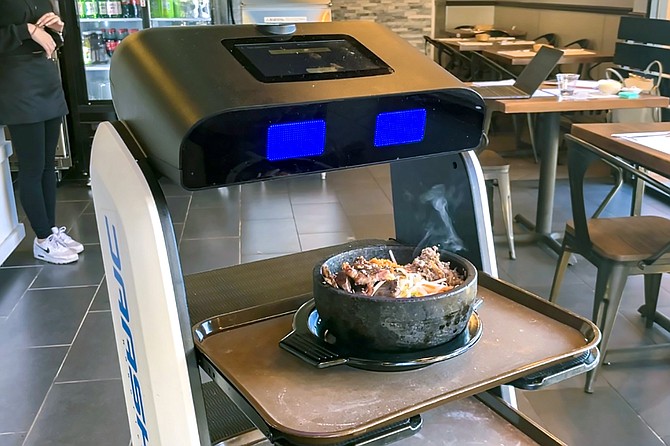 A service robot delivers hot stone bibimbap at the new college area Tofu House.
