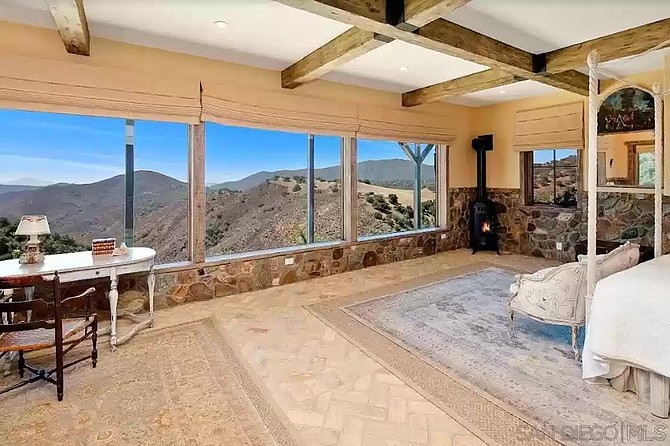 The 500-square-foot master bedroom, equipped with pot-bellied stove and a workspace with a view.