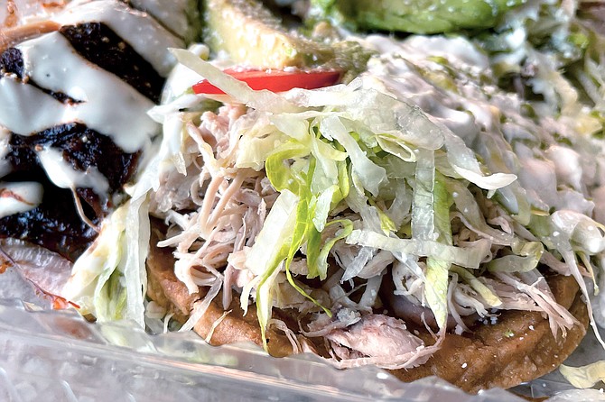 A pulled chicken sope, part of a comination plate of antojitos