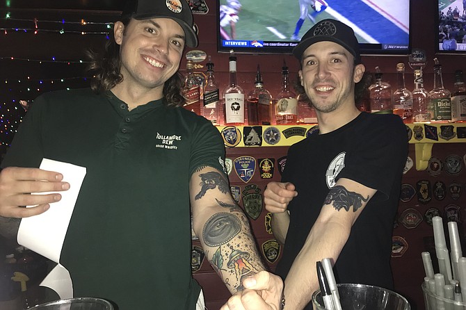Affable barkeeps, brothers James and Tom, show off their panther tats.
