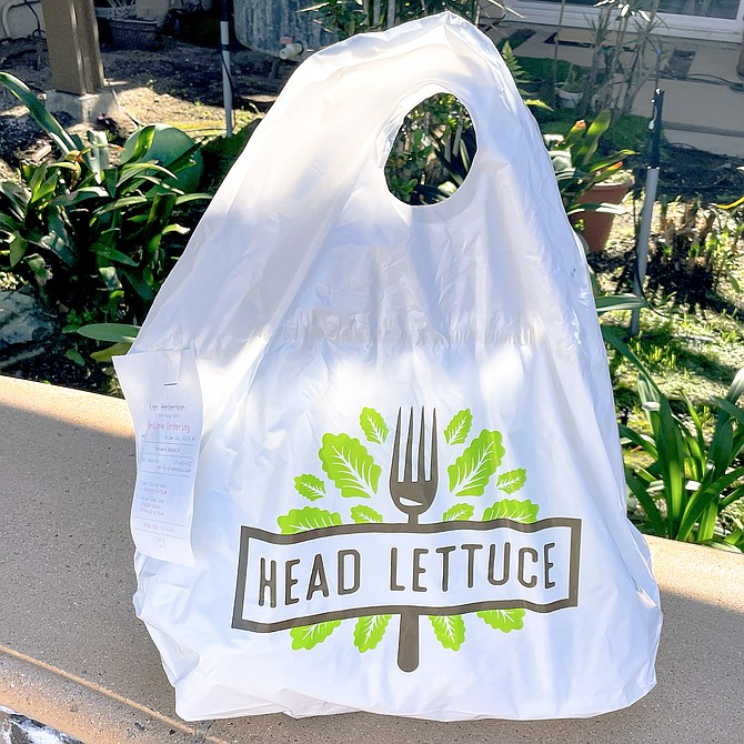 A sealed take-out bag from Head Lettuce