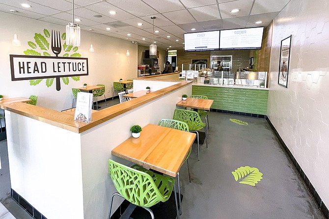 A salad shop sits empty during the lunch rush, except for a masked man picking up a dozen to-go orders.