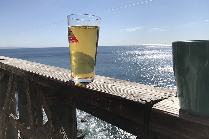 Pint of beer on bar’s balustrade, above the Pacific.