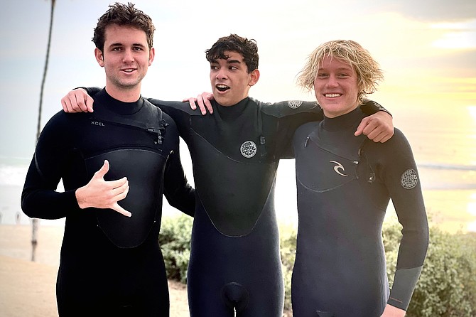 Will Michaels(17), Jaden Castellon(17), and Grant Huntley(18) surf T-street, San Clemente.