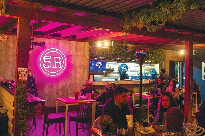 The shared taproom between Five Roots (Cinco Raíces) and Helmet (Casco) is a cozy, neat space with romantic light and a hip atmosphere inside metal shacks.