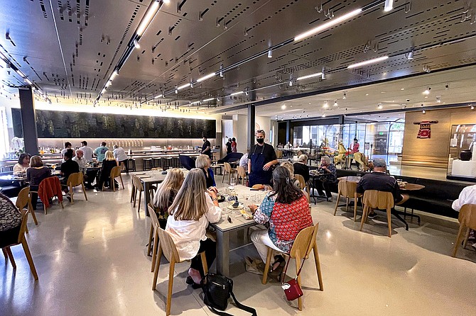 The Artifact dining room, inside the Mingei International Museum, features art pieces on the ceiling and over the bar in back.