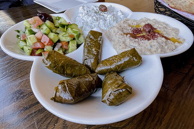 A meze platter of (clockwise from bottom): stuffed grape leaves, Iraqi salad, jajeek, and mtabbal