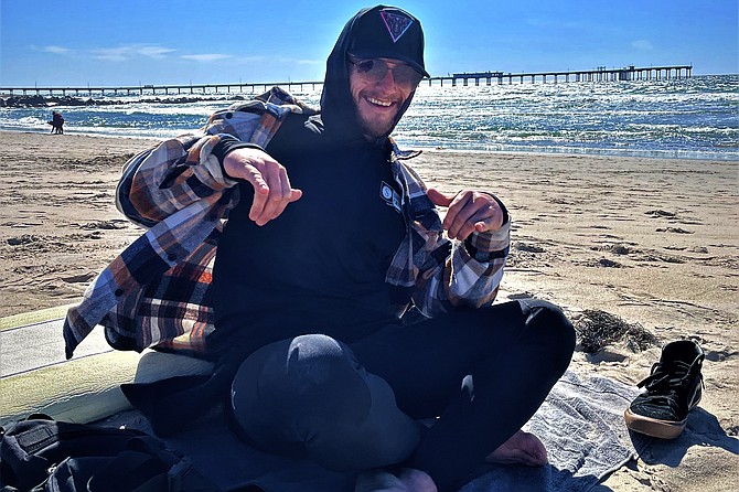 Caleb Cuen(26) surfs Dog Beach.