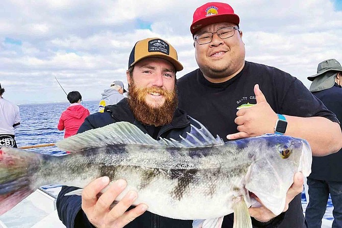 Captain Jason Coz with a jackpot-winning 7-pound sand bass caught by John Ho (R) aboard the Dolphin while fishing off Imperial Beach.