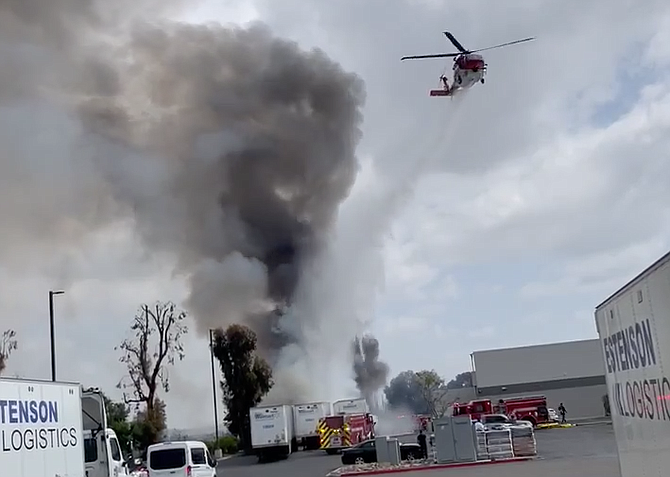 In Elias's 13-second clip, a helicopter is heard approaching from the east by the I-5 and Palm Avenue exit. It then flies into the frame, drops "pond water" onto the fire.