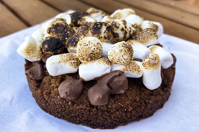 A s'mores cookie: thick graham cracker cookie topped by chocolate chips and toasted marshmallows
