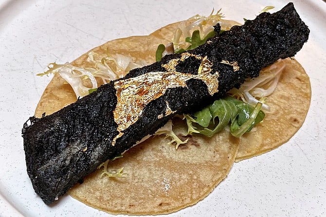 "The Taco": squid ink tempura fried sea bass topped by edible gold leaf