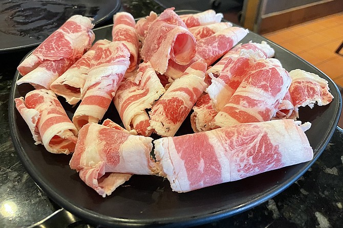 A plate of shaved beef belly, ready to grill