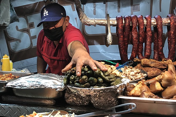 Amato reaches for the roast peppers, part of any taco meal.