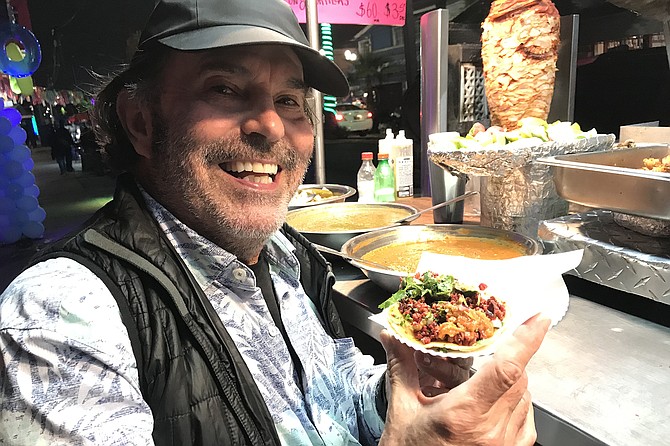 Neighbor Kevin holds his $1.50 chorizo taco before giving it to me.