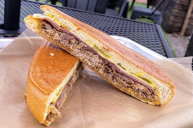 A cubano sandwich made with pulled pork, on a pressed telera roll
