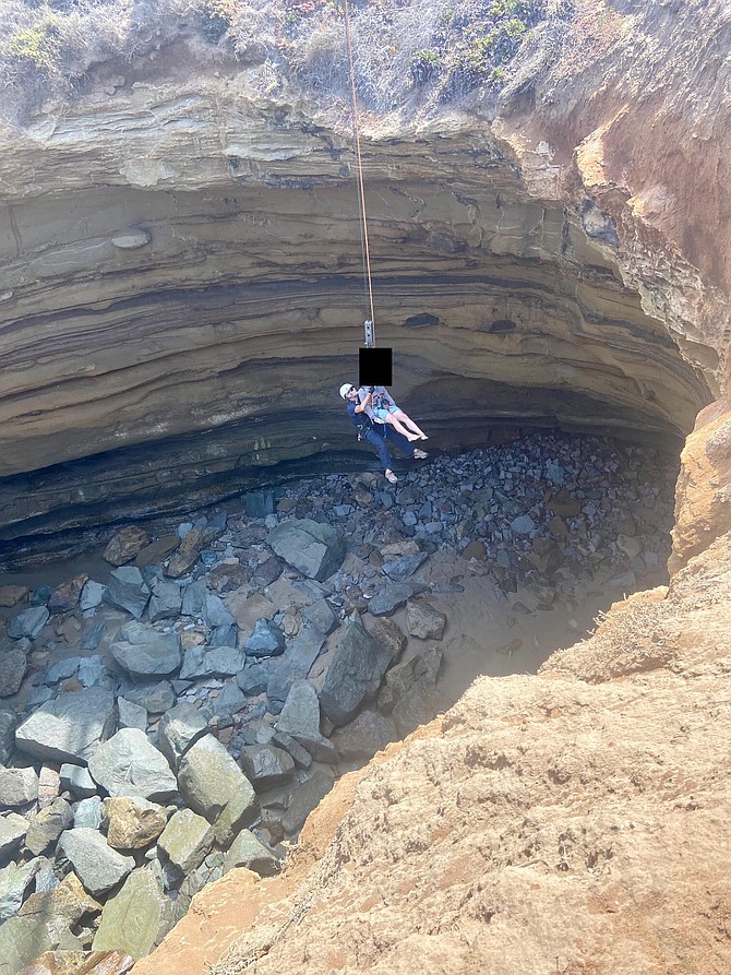 The lifeguard was hoisted above the 7-8 foot fence surrounding the cave's massive open ceiling, then slowly dropped down into the cave.