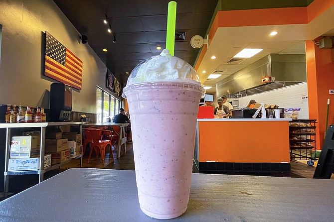 A strawberry milkshake with fresh strawberries blended in