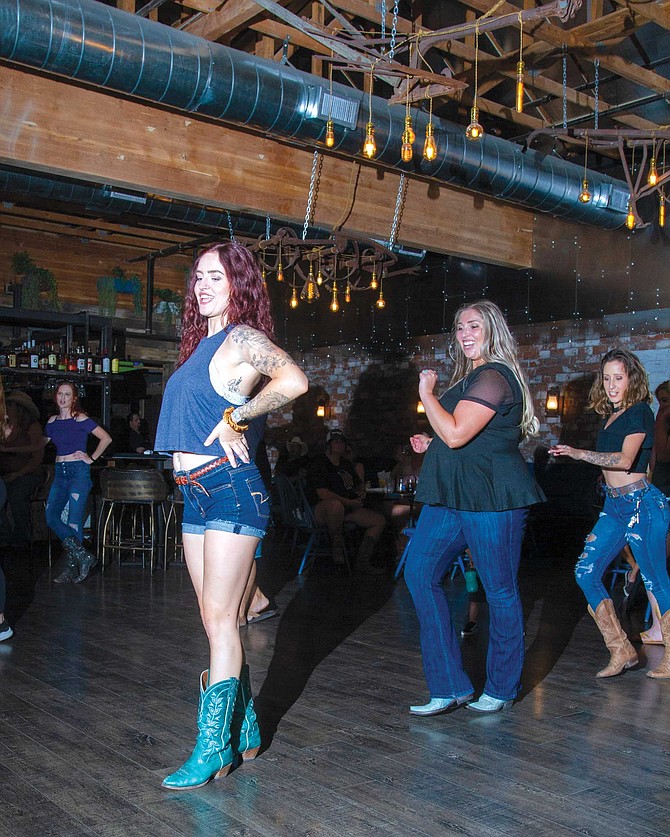 Kaitlyn Maracle (middle) is out on the dance floor at The Barn, all smiles and rhythm.