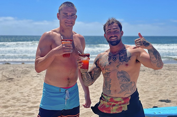 Bobby Lavargna (27) and Zach Senap (25) surf the Imperial Beach Pier