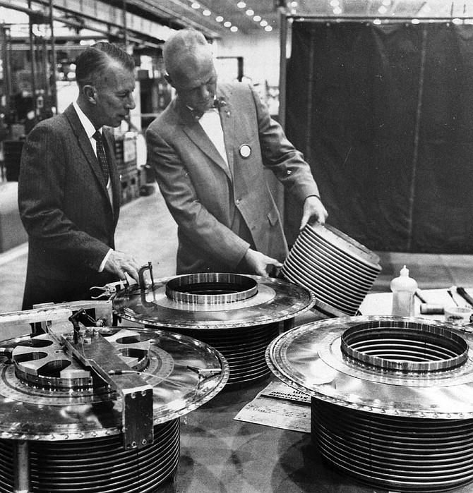 Glenn (right) handles component of Atlas at plant.
