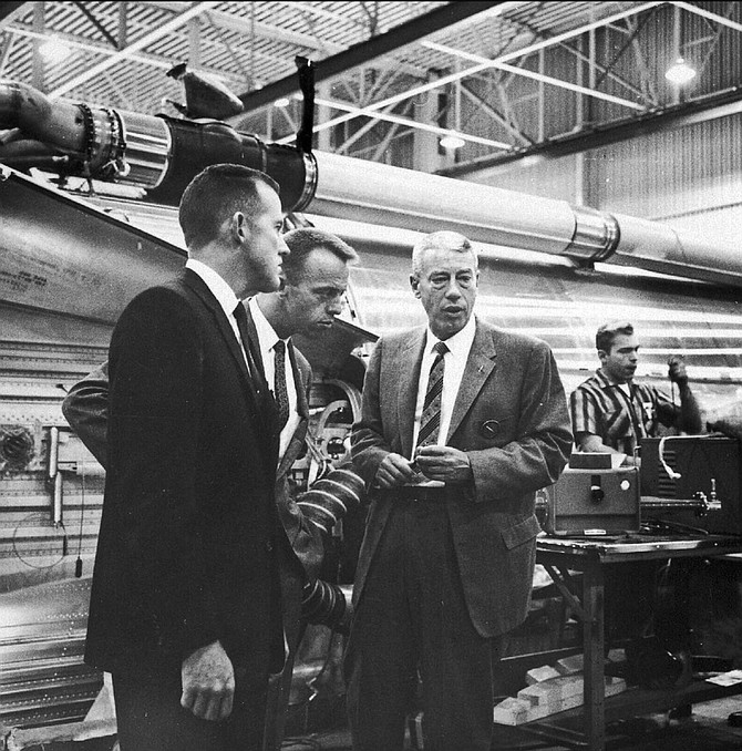 Shepard (middle individual) leans in to hear Convair executive at Atlas plant.