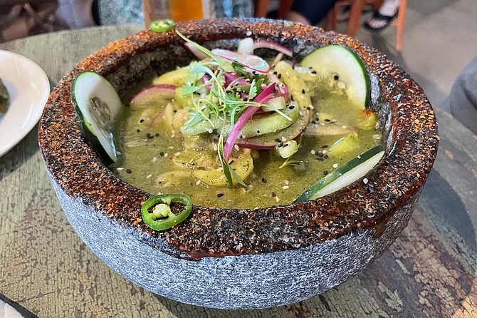 A green aguachile, served in a stone molcajete