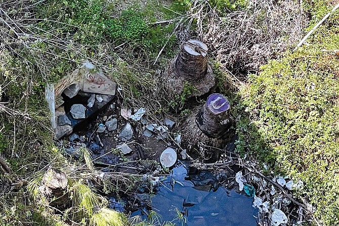Evidence of homeless encampments under the Vermont Street Bridge, including a makeshift toilet.