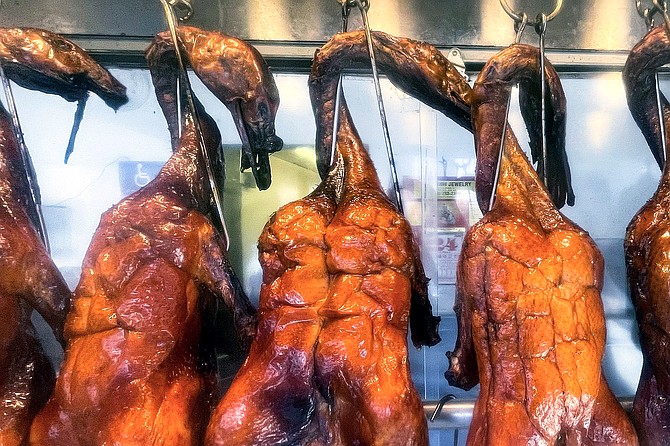 Roasted ducks hang behind the counter at Tom's Chinese BBQ