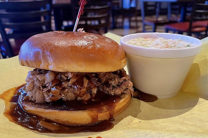 Coleslaw and a brisket sandwiched smothered in BBQ sauce