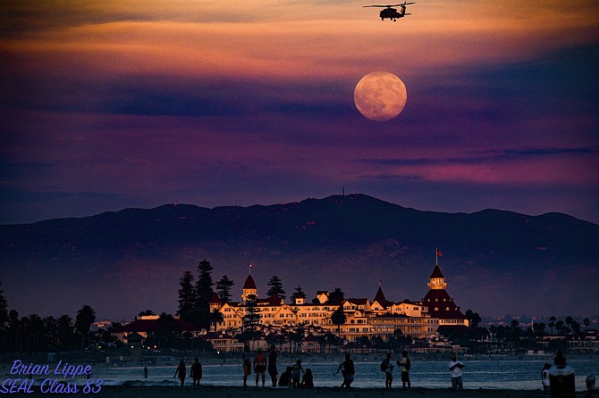 The full "Sturgeon Moon" with Otay Mountain in back of the Iconic Hotel Del Coronado. The sun was setting with the last rays of light for the on the Del. A Navy Helicopter from North Island was coming in to North Island over Dog Beach.