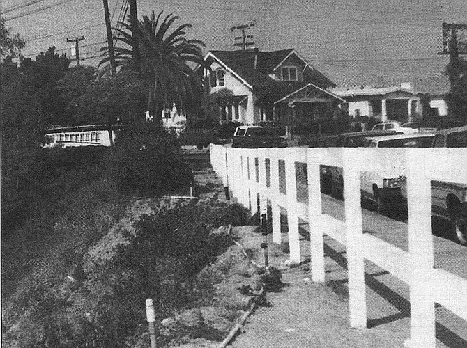 The filled-in canyon between University Avenue and old Douglas Street, still looks like a filled-in canyon. And the street still boasts its white wooden 1944-vintage road barriers. We are looking west-northwest.
