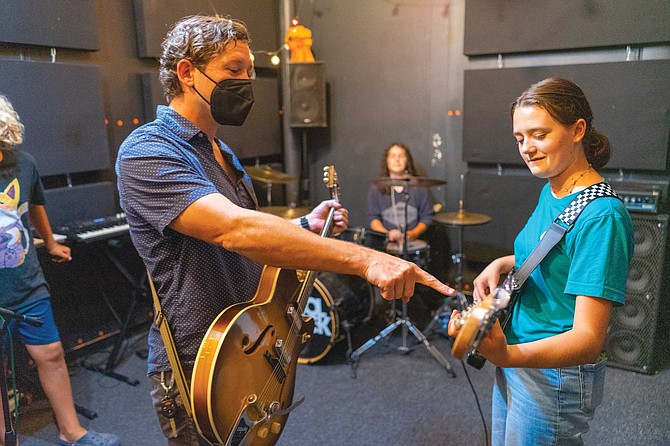 “Our goal is instead of parents saying, ‘You have to go practice today!’ parents are like, ‘Would you please put down your guitar? It’s time to go. Stop practicing please. It’s time to leave!’” So far, he’s succeeded: Tyler Ward’s (left) music geek personality is something to which the kids at the school seem drawn.