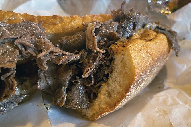 A cheesesteak with thinly shaved beef and light cheese