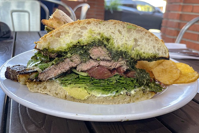 A grilled steak sandwich with chimichurri and roasted tomato, add avocado