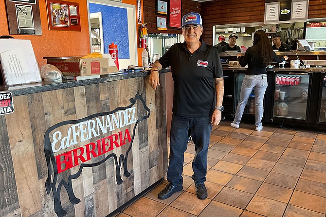 Jorge Fernandez beside the sign that memorializes his brother Ed