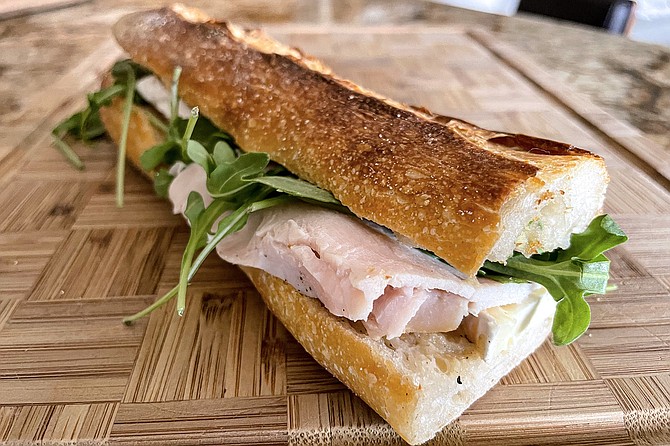 Grab and go baguette sandwich topped with turkey, brie, and sliced apples