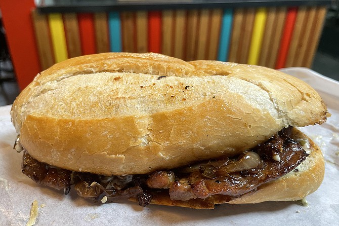 Seasoned pork chop with caramelized onions on a bolillo roll