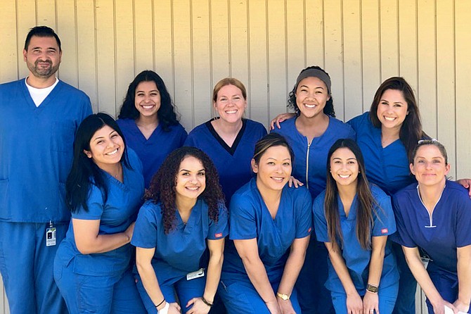 “We stand near Avocado Acute’s information desk, all of us decked out in blue scrubs. We look like a family of Smurfs.”