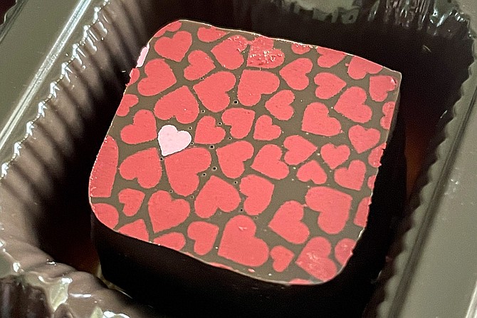 A dark chocolate ganache, with heart shaped stencils across the top