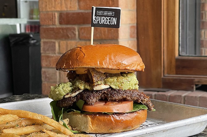 The "Spurgeon Infit" burger: angus brisket patty topped by guacamole, tomato, spinach, chipotle and sriracha mayos, grilled panela cheese, and chicharrones in salsa verde.