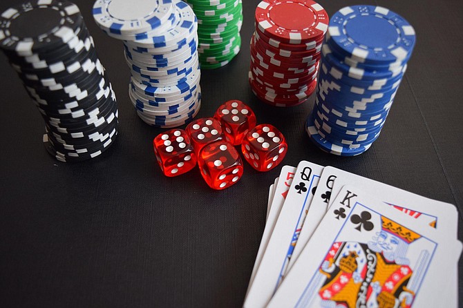 SPONSORED CONTENT Playing cards, casino chips, and red dice on the table.