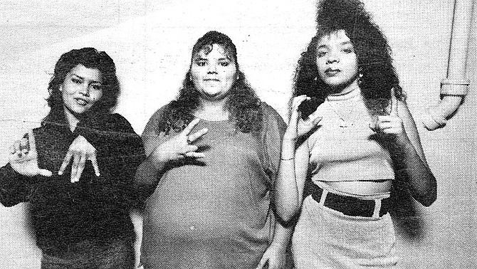 Bam-Bam, Cookie, and Joker, demonstrating hand signals "Lomas," "26," "Chicas #1." Joker testifies that she learned about the shooting from the homeboys hanging out at Dave’s Market at 26th and Broadway. - Image by Robert Burroughs