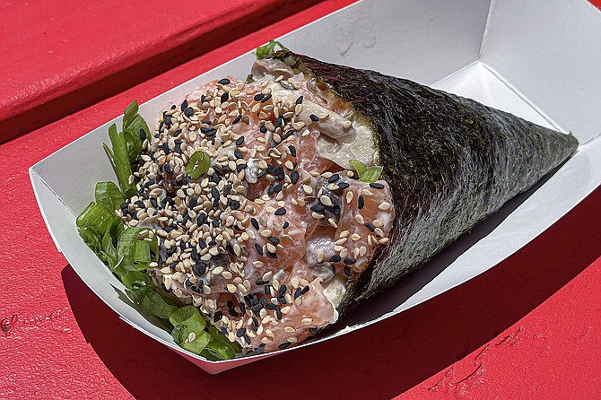A huge hand roll filled with raw salmon and sautéed himeji mushrooms