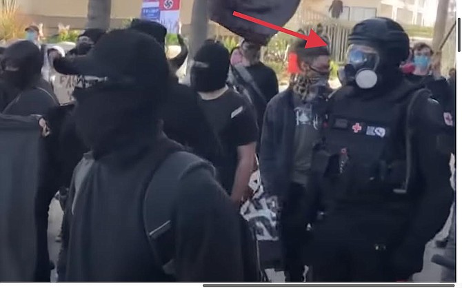Detective Clark described White as dressed from “head to toe in body armor” and wearing a gas mask over a black balaclava.