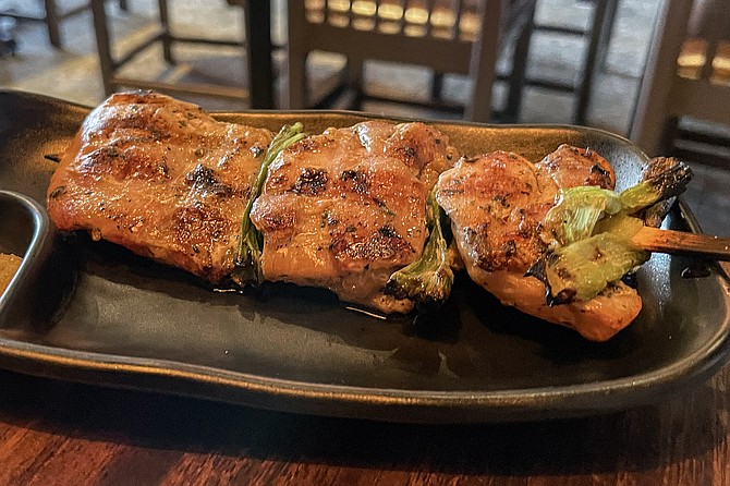 A large chicken thigh skewer with green onions