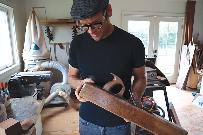 Guitar builder Andy Powers in his home shop with a 100-year-old block plane he still uses.