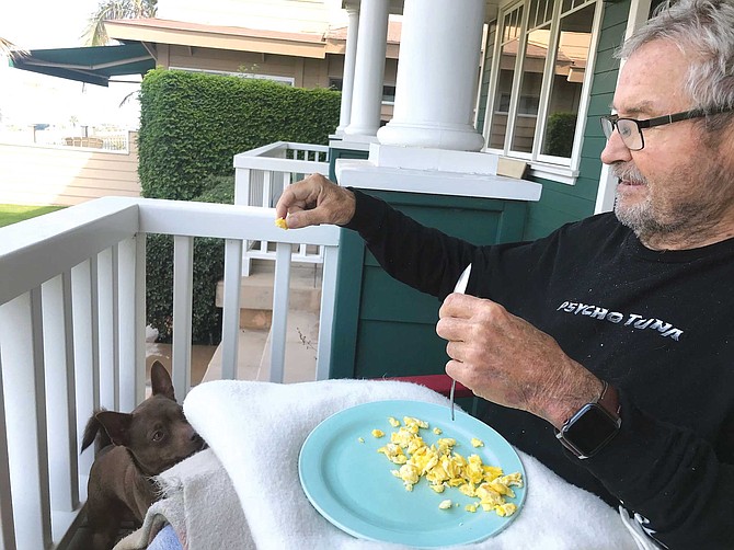 Hansen Surfboards' founder Don Hansen at home with his dog, Taco.
