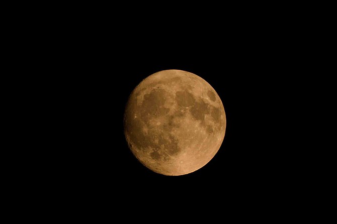 When the moon is close to the horizon it appears to be larger, it also travels through more atmosphere often giving it an orange color.